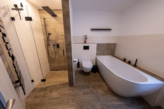 Abgerundete Badewanne, spülrandloses WC und Duschanlage