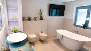 freistehende Badewanne, Toilette mit Bidet und Aufsatzwaschtisch